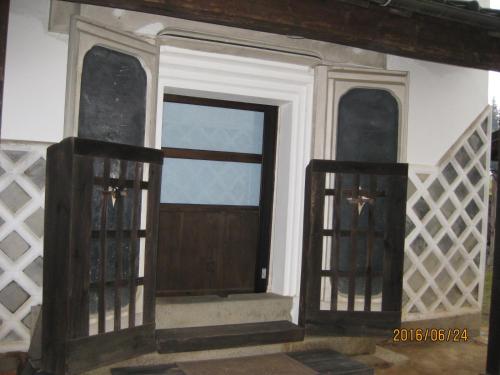 a house with a wooden door and a window at Guest House Shimoze Agematsu in Iida