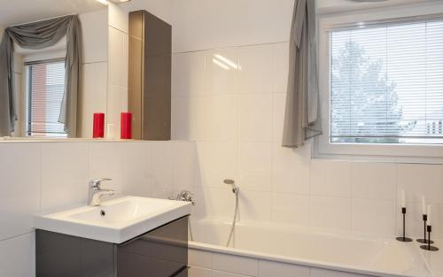 y baño blanco con lavabo y bañera. en Ferienhaus Mainz en Mainz