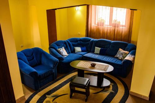 a living room with a blue couch and a table at Piatra Rancii in Ranca