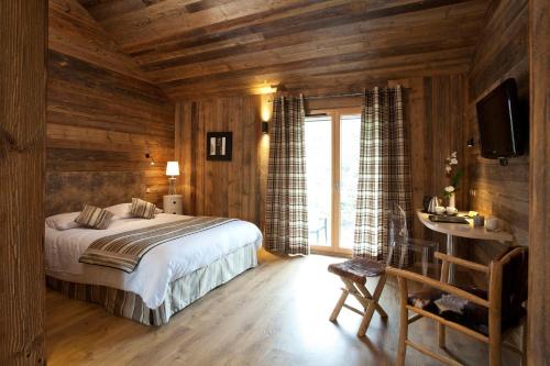 Schlafzimmer mit einem Bett, einem Schreibtisch und einem TV in der Unterkunft Hotel Blanc in Marigny-Saint-Marcel