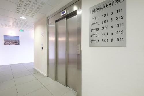 an elevator in a building with a sign on the wall at All Suites Appart Hôtel - Dunkerque Centre in Dunkerque