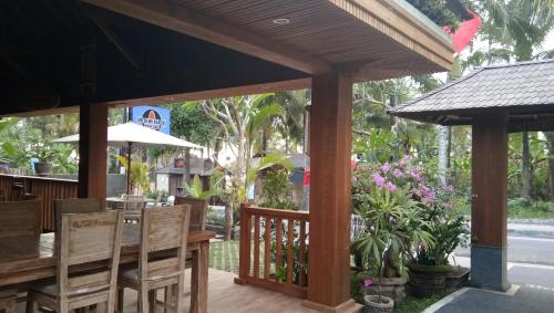 a patio with a wooden table and chairs at Medewi Beach Inn in Pulukan