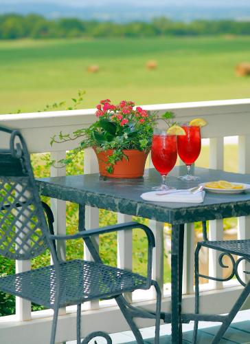 een tafel met twee glazen en een plant op een veranda bij Rose Hill Retreat AAA Four Diamond Inn in Stonewall