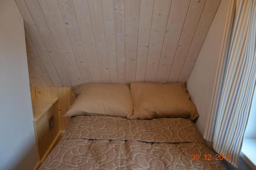 a small bed in a small room with a ceiling at Domek Klimaty- Kamieńczyk in Międzylesie