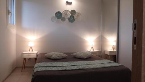 a bedroom with two pillows on a bed with two lamps at Résidence les Hameaux de Bocca del Oro in Porto-Vecchio