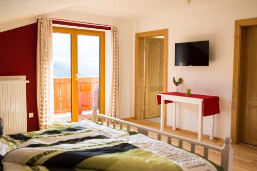 a bedroom with a bed and a table and a window at Laxhube in Gmünd in Kärnten