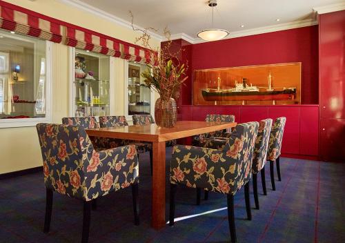 a dining room with a wooden table and chairs at Neptun Hotel Kühlungsborn in Kühlungsborn