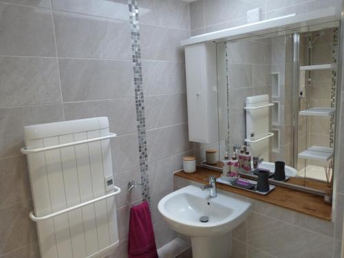 a white bathroom with a sink and a mirror at Becws Clyd in Trawsfynydd