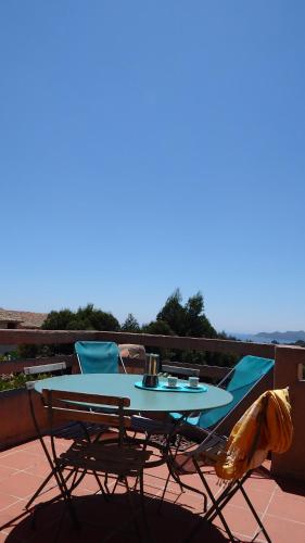 a table and chairs sitting on a balcony at Résidence les Hameaux de Bocca del Oro in Porto-Vecchio