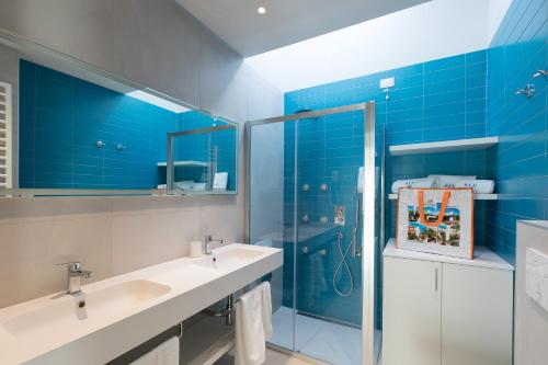 a bathroom with two sinks and a glass shower at Vela Blu Camping Village in Cavallino-Treporti