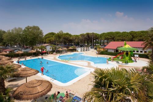 a pool at a resort with people playing in it at Vela Blu Camping Village in Cavallino-Treporti