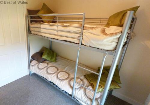 מיטה או מיטות קומותיים בחדר ב-Beudy Tawe