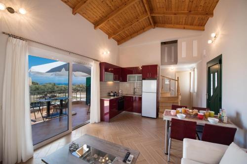 a kitchen and living room with a view of a mountain at Lefkogea Villas & Apartments in Tsoukaladhes