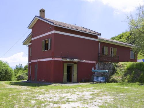 een rood huis met een bank ervoor bij Belvilla by OYO Casa grande in Corvara