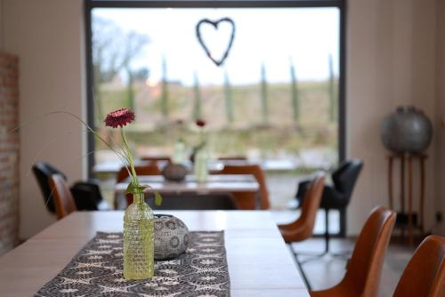 a vase on a table with a flower in it at Vinotel Dollt-Kern in Flemlingen
