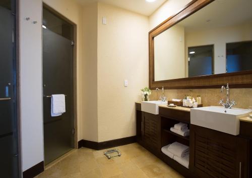 
a bathroom with a sink, toilet, and mirror at Dreams Riviera Cancun Resort & Spa - All Inclusive in Puerto Morelos
