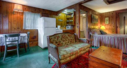 ein Wohnzimmer mit einem Sofa, einem Bett und einem Kühlschrank in der Unterkunft Cottage Place on Squam Lake - Cabins in Holderness