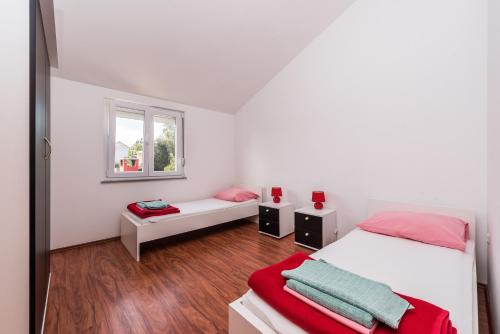 een slaapkamer met 2 bedden en een raam bij House Danica in Obrovac