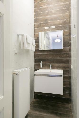 a bathroom with a white sink and a mirror at The City Palace - R.Q.C. in The Hague