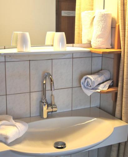 a bathroom with a sink and a mirror and towels at Apartments Auenheim in Prägraten