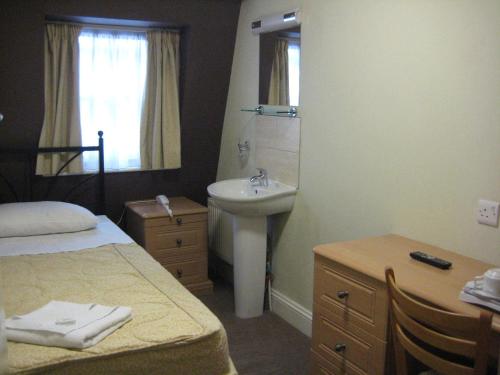 a bedroom with a bed and a sink and a mirror at Central Hotel in London