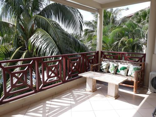 a porch with a bench on a balcony with palm trees at Savoy Hotel Boutique in Las Terrenas