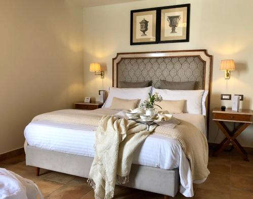 a bedroom with a large white bed with a table at Four Points Flex by Sheraton Naples Marigliano in Marigliano
