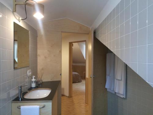 a bathroom with a sink and a hallway at SOBRE RIBAS 2|12 in Coimbra