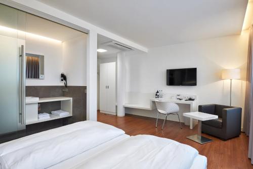 a bedroom with a bed and a desk and a tv at Fairotel in Filderstadt