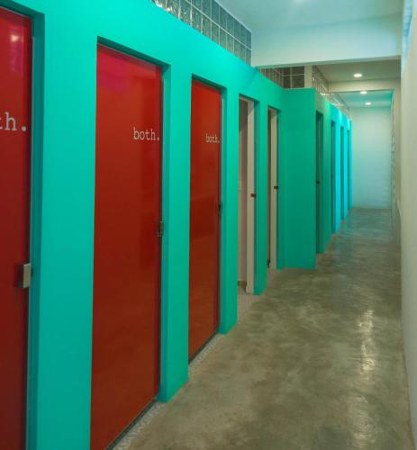 a row of red and blue doors in a hallway at Hostel Frente al Mar Tropico 20º in Cozumel