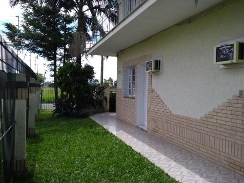 a building with a staircase next to a yard at Ville House Hotel Canoas in Canoas