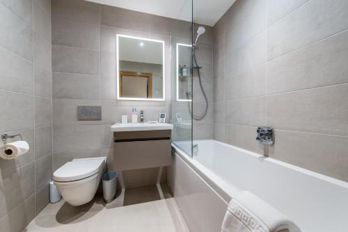 a bathroom with a tub and a toilet and a sink at Dalriada Lodges Skatie in Stonehaven
