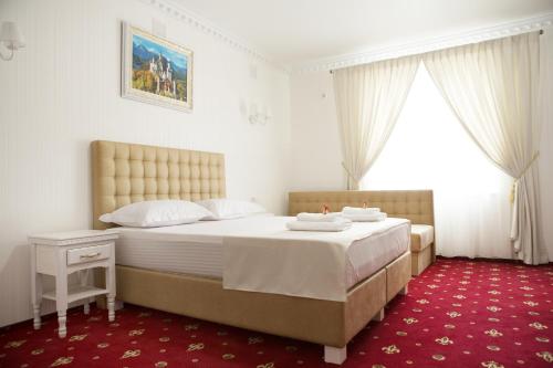 a bedroom with a large bed and a red carpet at Bavaria in Hatne