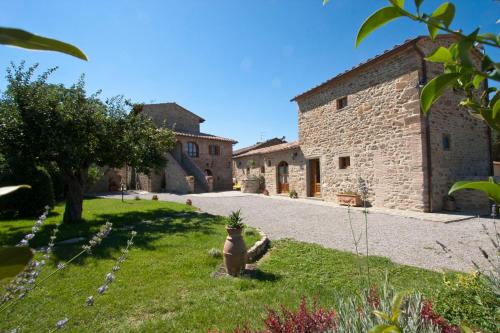 a stone building with a yard in front of it at Casale l'Antico Carro in Cortona