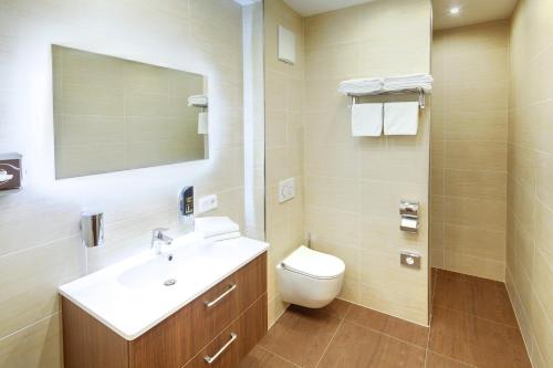 a bathroom with a toilet a sink and a shower at Hotel Füssen in Füssen