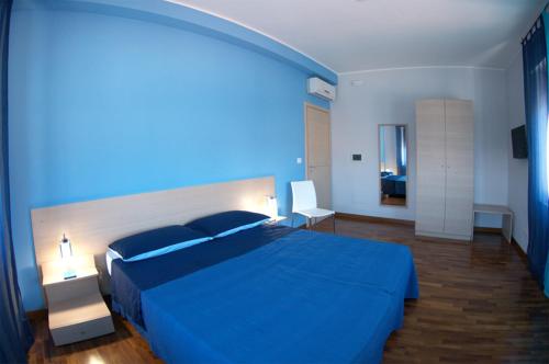 Un dormitorio azul con una gran cama azul. en B&B Santa Caterina en Reggio Calabria