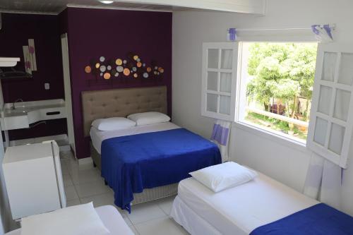a room with two beds and a sink and a window at Casa da Maisa in Porto Seguro