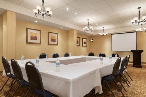 a conference room with a table and chairs and a screen at Days Inn by Wyndham Edmonton Downtown in Edmonton