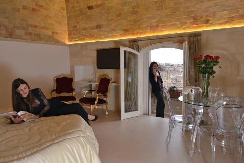a woman is sitting on a bed in a room at Antica Torre di Iuso in Matera