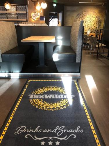 a restaurant with a table and a rug on the floor at Hotel Lapuahovi in Lapua