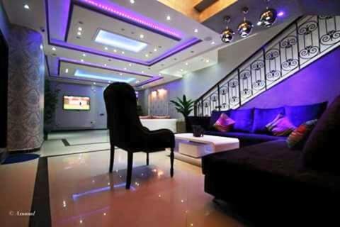 a purple room with a chair and a couch at Balcon Bleu in Chefchaouene