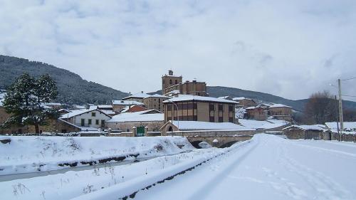 a town covered in snow with a train station at Hotel Virginia R.H. in Vinuesa