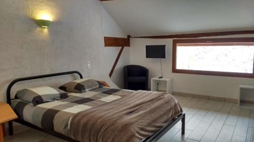 a bedroom with a bed and a desk and a window at Hôtel - Gîte de Pressins in Pressins
