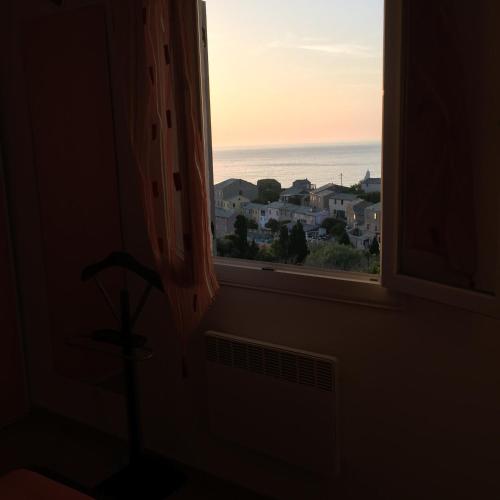 a window in a room with a view of the ocean at La Giraglia in Centuri