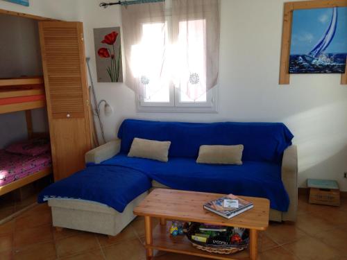 Sofá azul en la sala de estar con mesa en La Giraglia, en Centuri
