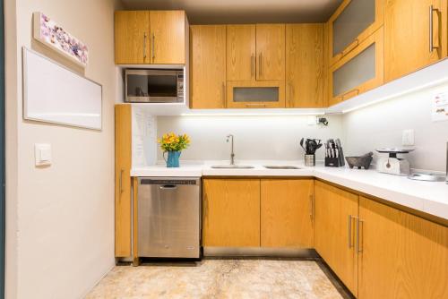 a kitchen with wooden cabinets and a sink at La Palomilla Bed & Breakfast in Mexico City