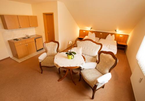une chambre d'hôtel avec un lit, une table et des chaises dans l'établissement Weinbau & Pension "8Zeilen", à Golk