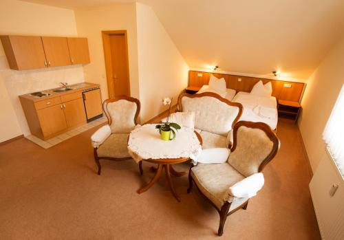 a hotel room with a bed and a table and chairs at Weinbau & Pension "8Zeilen" in Golk