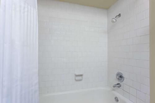 a white bathroom with a tub and a shower at Days Inn By Wyndham Bellingham WA in Bellingham