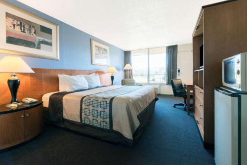 una camera d'albergo con un grande letto e una TV di Days Inn by Wyndham Luray Shenandoah a Luray